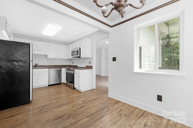 10101 Wood Ct, Charlotte, NC 28277 - kitchen featuring stainless steel appliances, dark countertops, white cabinetry, and a chandelier