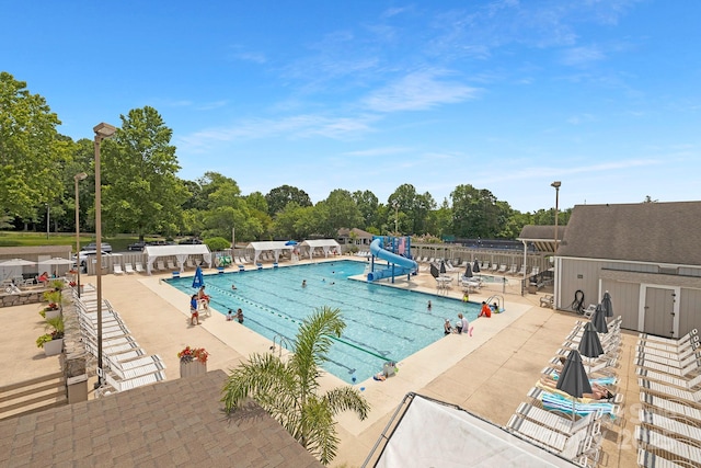 10101 Wood Ct, Charlotte, NC 28277 - community pool with a water slide, a patio, and view of wooded area