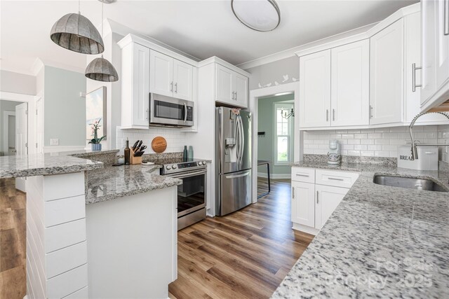 3902 Mcgee Point Rd, Terrell, NC 28682 - kitchen with stainless steel appliances, a sink, crown molding, wood finished floors, and white cabinets