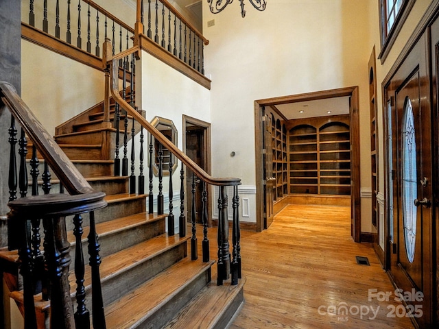 4672 Snow Dr, Harrisburg, NC 28075 - foyer entrance featuring a towering ceiling, wood finished floors, stairway, and a chandelier
