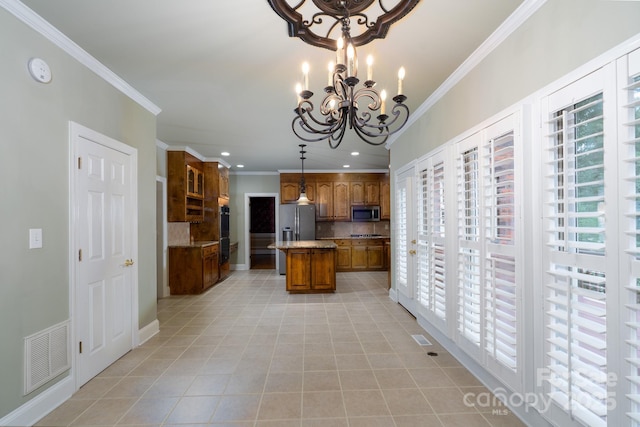 4672 Snow Dr, Harrisburg, NC 28075 - kitchen featuring stainless steel appliances, brown cabinets, crown molding, decorative backsplash, and a kitchen island