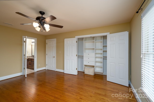 4672 Snow Dr, Harrisburg, NC 28075 - unfurnished bedroom with wood finished floors, baseboards, a ceiling fan, and connected bathroom