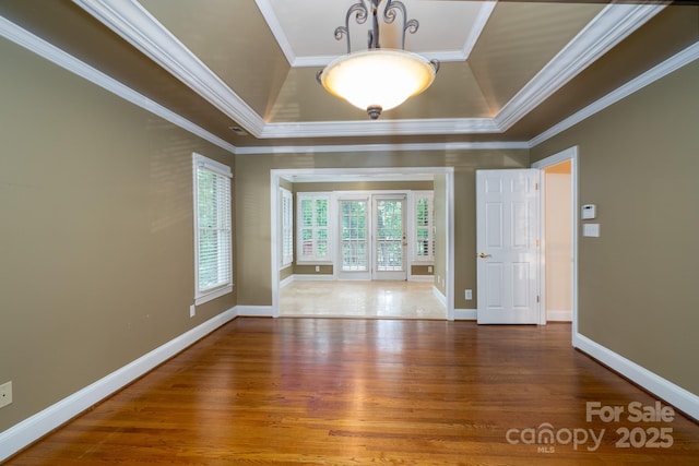 4672 Snow Dr, Harrisburg, NC 28075 - spare room featuring a tray ceiling, wood finished floors, ornamental molding, and baseboards