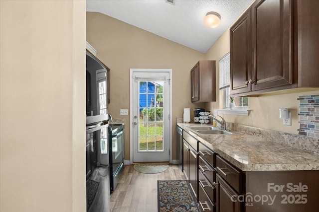 209 Mcfadden St, Rock Hill, SC 29730 - kitchen with vaulted ceiling, dark brown cabinets, appliances with stainless steel finishes, light wood finished floors, and washer and clothes dryer
