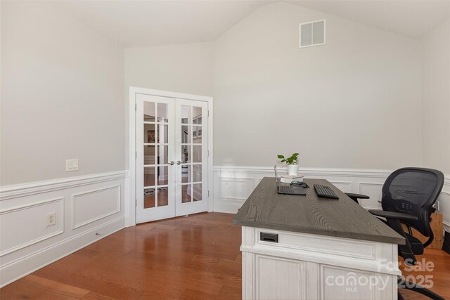 10106 Silverling Dr, Waxhaw, NC 28173 - home office featuring french doors, wood finished floors, vaulted ceiling, wainscoting, and a decorative wall