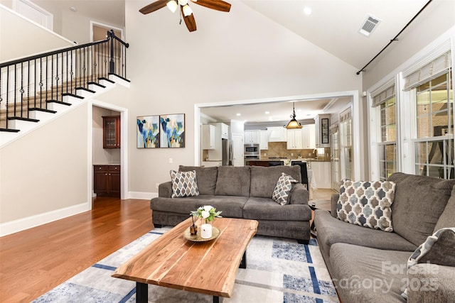 10106 Silverling Dr, Waxhaw, NC 28173 - living area featuring light wood-type flooring, a ceiling fan, stairs, recessed lighting, and high vaulted ceiling