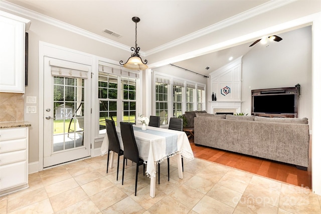 10106 Silverling Dr, Waxhaw, NC 28173 - dining room featuring ornamental molding, healthy amount of natural light, a fireplace, vaulted ceiling, and ceiling fan