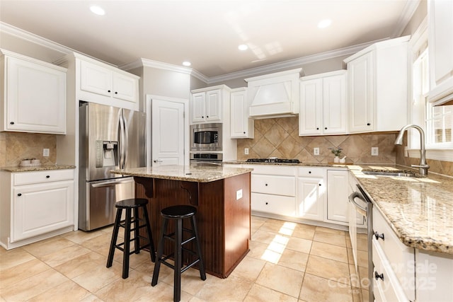 10106 Silverling Dr, Waxhaw, NC 28173 - kitchen featuring appliances with stainless steel finishes, premium range hood, a center island, white cabinets, and tasteful backsplash