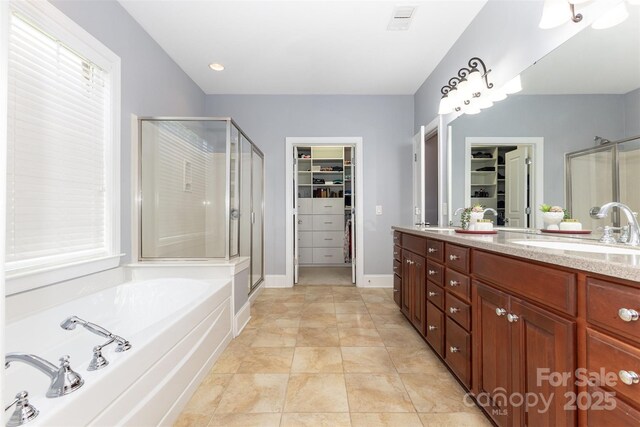 10106 Silverling Dr, Waxhaw, NC 28173 - bathroom with a spacious closet, a stall shower, double vanity, and a garden tub