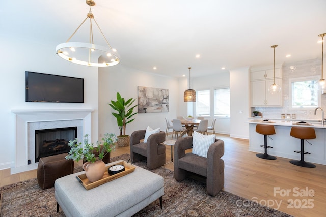 4203 Walker Rd, Charlotte, NC 28211 - living area with light wood finished floors, a chandelier, recessed lighting, and a fireplace