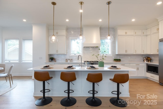 4203 Walker Rd, Charlotte, NC 28211 - kitchen with custom range hood, light countertops, a breakfast bar area, backsplash, and recessed lighting