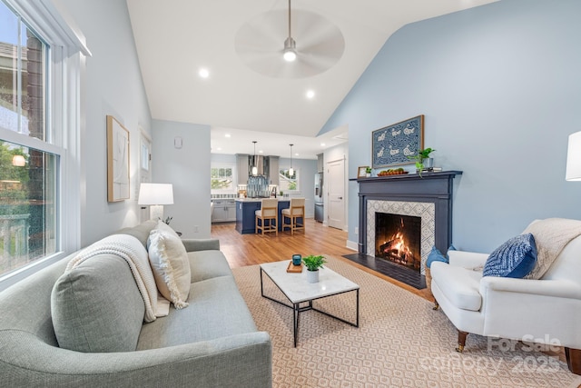 2421 Morton St, Charlotte, NC 28208 - living area featuring light wood finished floors, high vaulted ceiling, a ceiling fan, recessed lighting, and a tiled fireplace
