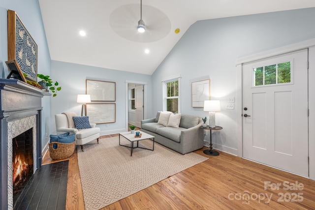 2421 Morton St, Charlotte, NC 28208 - living area featuring a ceiling fan, a fireplace with flush hearth, wood finished floors, healthy amount of natural light, and high vaulted ceiling