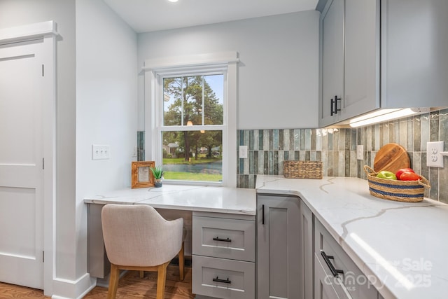 2421 Morton St, Charlotte, NC 28208 - kitchen with gray cabinets, decorative backsplash, light stone countertops, and wood finished floors