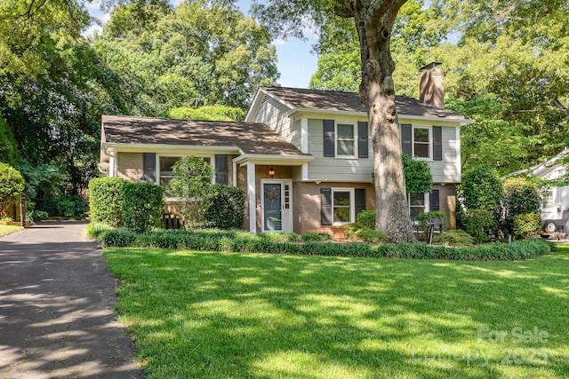 4200 Tyndale Ave, Charlotte, NC 28210 - tri-level home with brick siding, a chimney, and a front yard