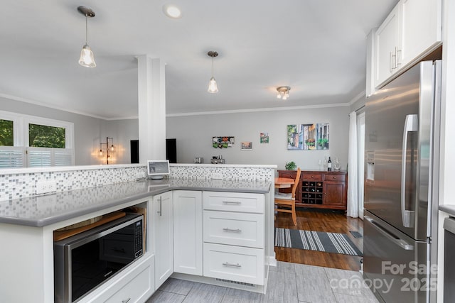 4200 Tyndale Ave, Charlotte, NC 28210 - kitchen with stainless steel appliances, crown molding, white cabinetry, decorative light fixtures, and light wood-style floors
