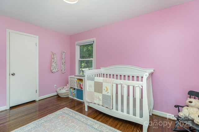 4200 Tyndale Ave, Charlotte, NC 28210 - bedroom featuring wood finished floors, baseboards, and a crib
