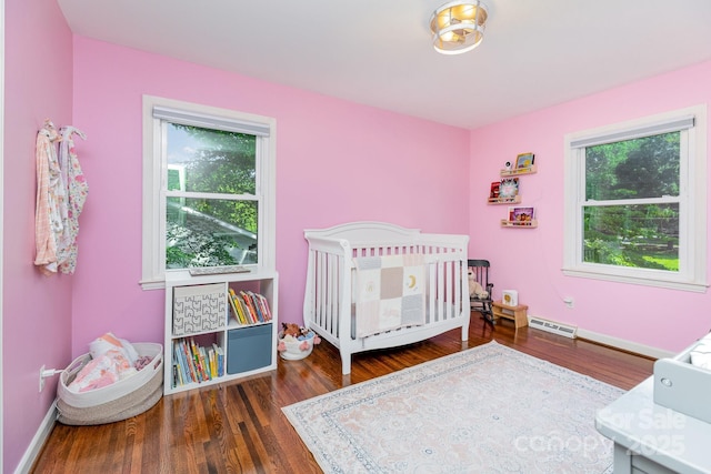 4200 Tyndale Ave, Charlotte, NC 28210 - bedroom featuring multiple windows, wood finished floors, and a crib
