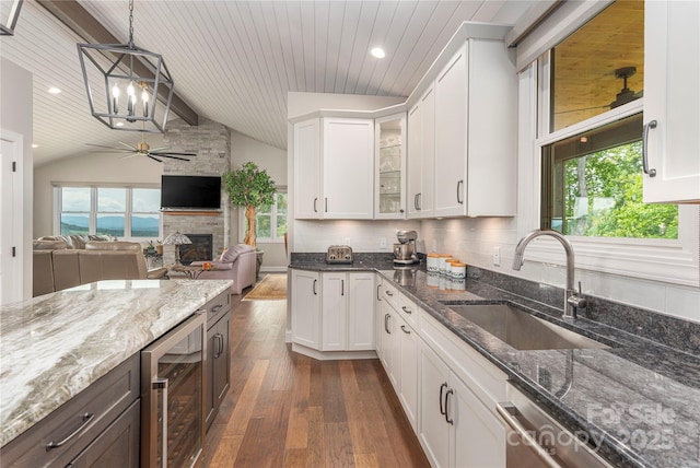 24 Herron View Ln, Weaverville, NC 28787 - kitchen with beverage cooler, dark wood-style floors, a stone fireplace, a ceiling fan, and vaulted ceiling