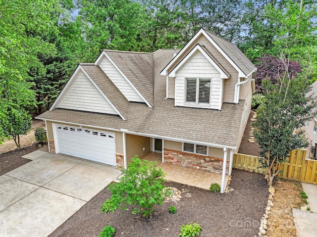 50 Beekeeper Trl, Swannanoa, NC 28778 - view of front of house with a garage, a shingled roof, stone siding, driveway, and view of scattered trees