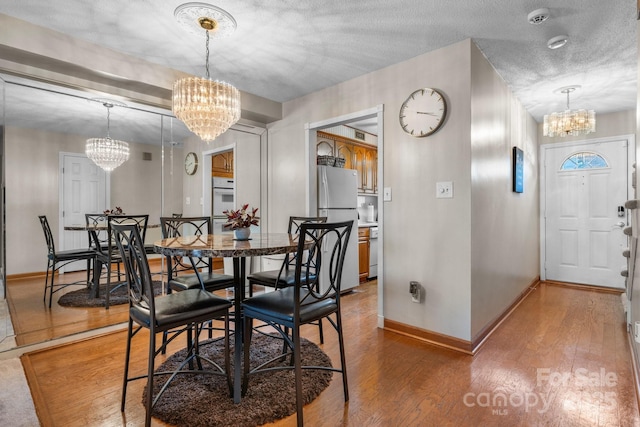 1330 5th St NE Unit 11, Hickory, NC 28601 - dining room featuring a chandelier, light wood-type flooring, and baseboards