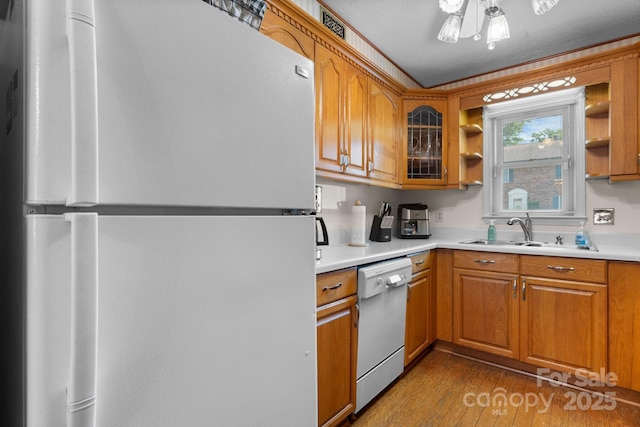 1330 5th St NE Unit 11, Hickory, NC 28601 - kitchen with freestanding refrigerator, dishwasher, a sink, brown cabinets, and wood finished floors