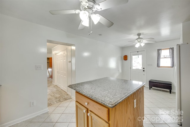 2111 Parkdale Ave, Gastonia, NC 28052 - kitchen featuring freestanding refrigerator, light tile patterned flooring, ceiling fan, a kitchen island, and baseboards