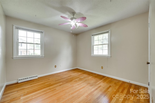 2111 Parkdale Ave, Gastonia, NC 28052 - unfurnished room with wood finished floors, baseboards, baseboard heating, a ceiling fan, and a textured ceiling