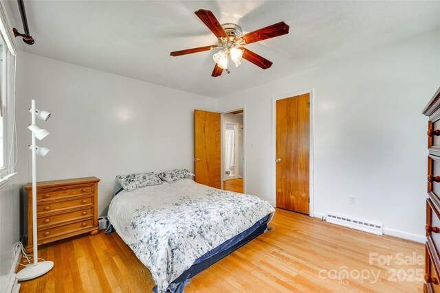 2111 Parkdale Ave, Gastonia, NC 28052 - bedroom featuring baseboard heating, light wood finished floors, ceiling fan, baseboards, and a baseboard radiator