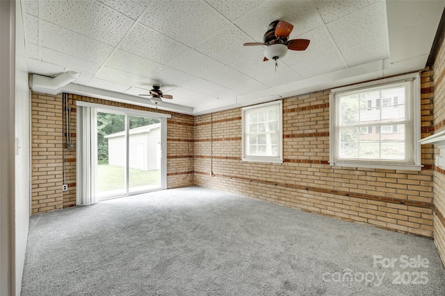2111 Parkdale Ave, Gastonia, NC 28052 - empty room with brick wall, carpet flooring, a drop ceiling, and a ceiling fan