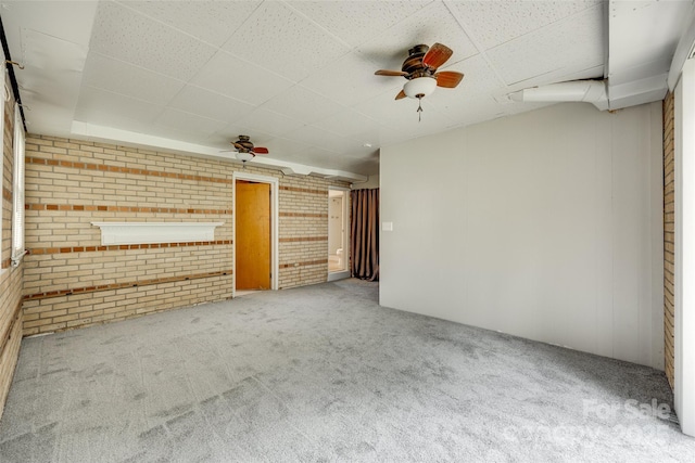 2111 Parkdale Ave, Gastonia, NC 28052 - empty room with brick wall, a drop ceiling, a ceiling fan, and carpet floors