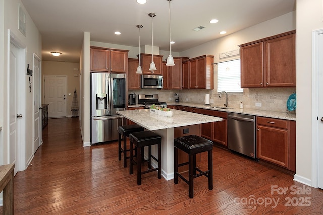 7328 Strawberry Fields Ln, Charlotte, NC 28278 - kitchen with stainless steel appliances, dark wood-style floors, a sink, a kitchen bar, and tasteful backsplash