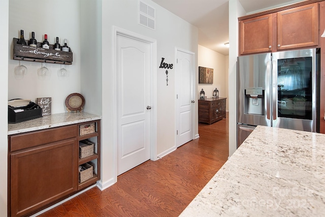 7328 Strawberry Fields Ln, Charlotte, NC 28278 - kitchen with stainless steel fridge with ice dispenser, dark wood-style floors, light stone countertops, and brown cabinetry
