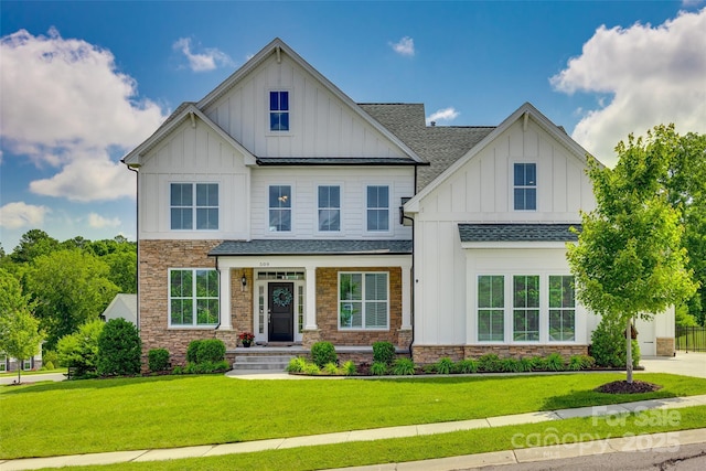 509 Abelia Ln, Tega Cay, SC 29708 - view of front of house with board and batten siding, stone siding, a shingled roof, and a front yard