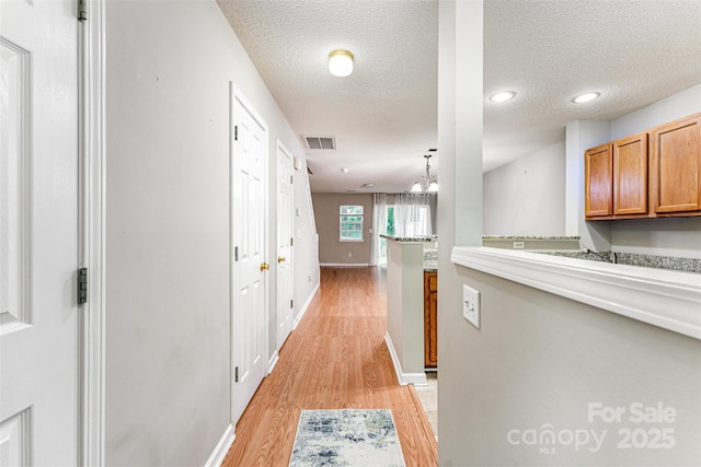 10223 Reindeer Way Ln, Charlotte, NC 28216 - corridor featuring light wood-type flooring, a textured ceiling, baseboards, recessed lighting, and a chandelier