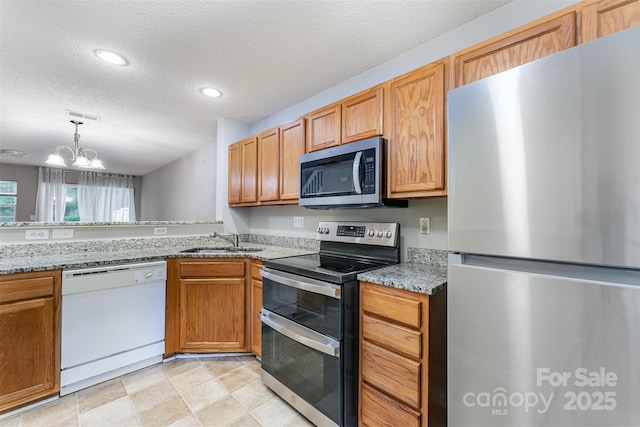 10223 Reindeer Way Ln, Charlotte, NC 28216 - kitchen featuring appliances with stainless steel finishes, a sink, a textured ceiling, a chandelier, and light stone countertops
