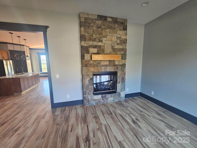 1076 Table View Dr Unit 55, Morganton, NC 28655 - unfurnished living room with wood finished floors, a fireplace, baseboards, and a sink