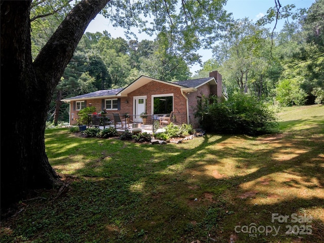 26 Melton Rd, Candler, NC 28715 - view of front facade featuring brick siding, a chimney, and a front yard