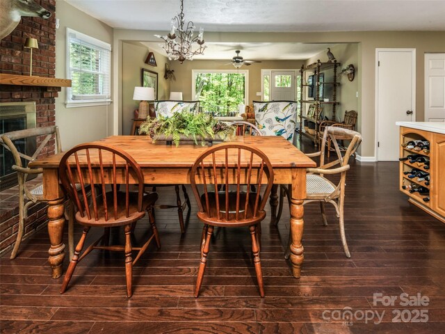 26 Melton Rd, Candler, NC 28715 - dining room with dark wood-style flooring, a brick fireplace, ceiling fan, a chandelier, and baseboards