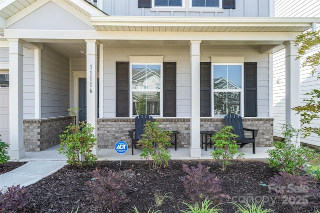 11116 Godwit Ln, Charlotte, NC 28278 - view of exterior entry featuring covered porch, board and batten siding, and stone siding
