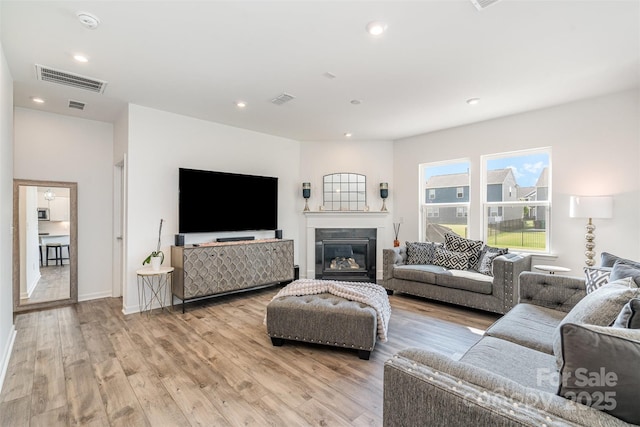 11116 Godwit Ln, Charlotte, NC 28278 - living area with light wood finished floors, recessed lighting, a glass covered fireplace, and baseboards