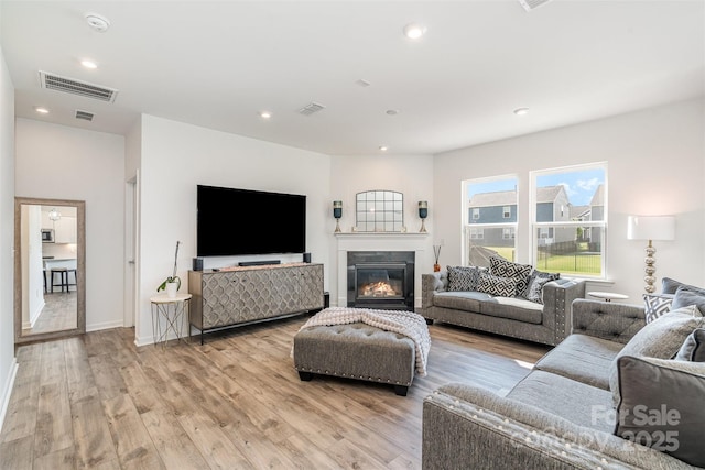 11116 Godwit Ln, Charlotte, NC 28278 - living area with light wood-style flooring, recessed lighting, a glass covered fireplace, and baseboards