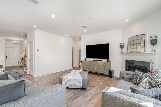 11116 Godwit Ln, Charlotte, NC 28278 - living room featuring light wood-style floors, a glass covered fireplace, recessed lighting, and baseboards