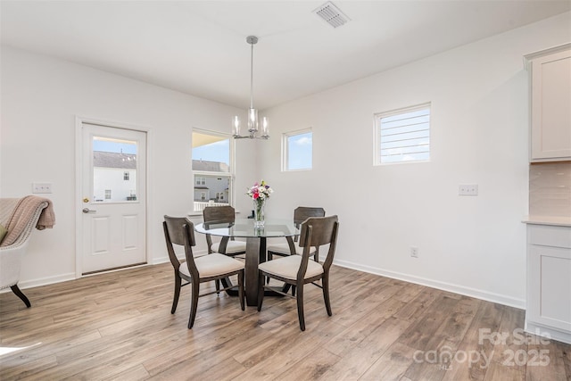 11116 Godwit Ln, Charlotte, NC 28278 - dining space featuring a chandelier, light wood-type flooring, and plenty of natural light