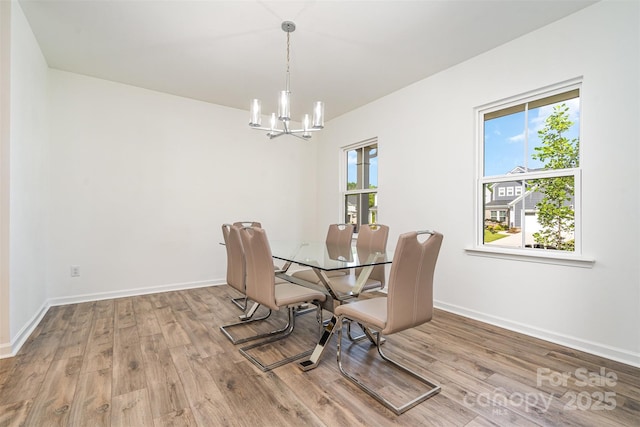 11116 Godwit Ln, Charlotte, NC 28278 - dining space featuring a chandelier, wood finished floors, and baseboards