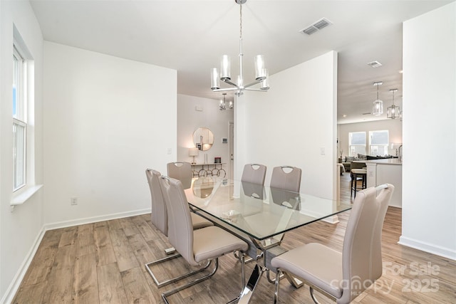 11116 Godwit Ln, Charlotte, NC 28278 - dining room with a chandelier, light wood finished floors, and baseboards