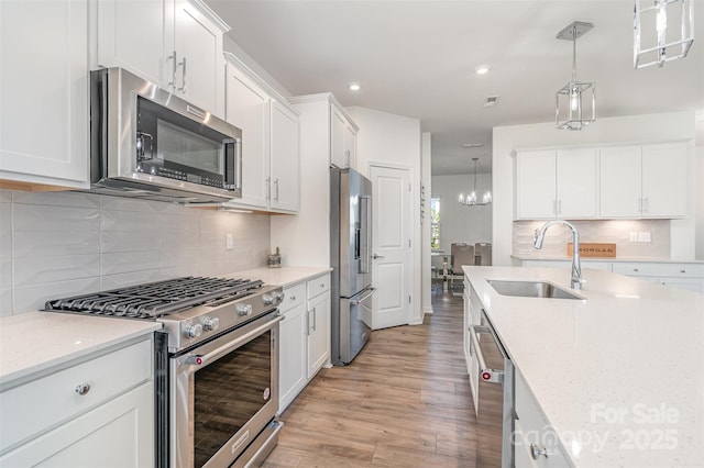 11116 Godwit Ln, Charlotte, NC 28278 - kitchen with high end appliances, a sink, white cabinetry, light wood-style floors, and recessed lighting