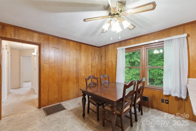 46 Donna Dale Ave SE, Concord, NC 28025 - dining space featuring wood walls, ceiling fan, light flooring, and crown molding