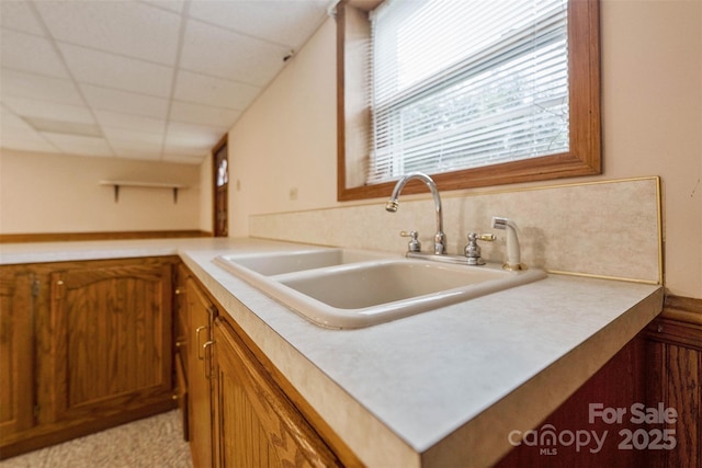 46 Donna Dale Ave SE, Concord, NC 28025 - kitchen with a sink, brown cabinetry, light countertops, and a drop ceiling