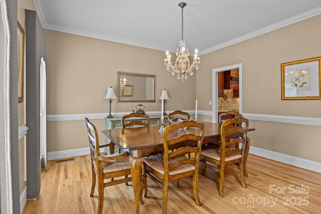 9717 Waterton Ct, Huntersville, NC 28078 - dining room featuring a chandelier, light wood finished floors, crown molding, and baseboards